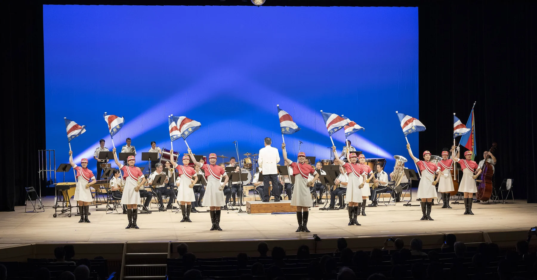 旗を掲げたカラーガード隊と音楽隊によるステージ演奏